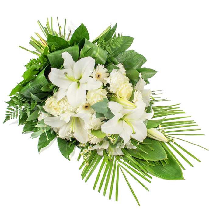 A refined, teardrop-style funeral spray is displayed against a stark white background, its form flowing diagonally as though it has been gently laid down in a moment of contemplation. Dominating the centre are grand white lilies, their trumpet-shaped blooms open wide with serene confidence, while a few upright buds hint at beauty that will unfold over the coming days. Tucked around these lilies are smaller white roses, some just beginning to unfurl their layered petals, others more open and soft, offering a classic, timeless touch. White carnations bring a cushion of ruffled petals, and simple white Gerbera-like flowers, each with a delicate cream or light yellow eye, create a subtle contrast in the heart of the arrangement. Tiny spray flowers in pure white dance between the larger heads, adding airiness and texture so the spray feels both full and light. A rich tapestry of greenery shapes the piece: glossy dark green leaves frame the blooms, while feathery ferns and softly rounded eucalyptus stems provide movement and depth. Near the upper section, long, ribbon-like foliage is folded and gathered in a vertical cluster, giving a sense of careful craftsmanship, while at the lower right, a fan of slender palm fronds stretches outward, guiding the eye along the spray's gently pointed silhouette. Designed as a one-sided tribute, meant to be appreciated from the front, this arrangement seems perfectly suited to rest by a coffin or at the front of a service room in Queensbury, perhaps in a small chapel or community space just off the busy Kingsbury or Honeypot Lane areas. The cool white flowers and natural greens come together to express purity, quiet dignity, and a deep, respectful farewell, offering a comforting sight for families gathering to remember a loved one.