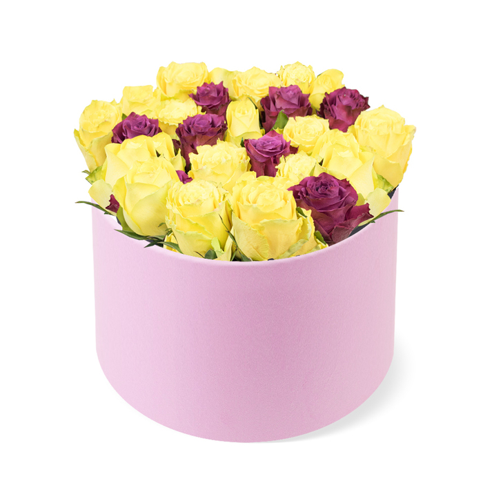 Viewed from a slightly elevated angle, this modern, cylindrical pastel pink gift box presents a contemporary twist on a classic bouquet. The smooth matte box curves around a scooped front opening, artfully revealing a dense cluster of blooms inside. The bouquet is dominated by numerous soft yellow flowers, their petals forming a sunny, rounded silhouette that feels both buoyant and reassuring. Interspersed among the yellows are burgundy or deep purple accents, smaller in scale but rich in color, creating a luxurious contrast that draws the eye inward. The arrangement sits tightly within the container, the blossoms mounding slightly above the rim to emphasize abundance and plushness. Very little greenery intrudes on the chorus of color, ensuring the petals and their tones remain the focal point. The white background and precise lighting make the pink tones glow, a perfect match for contemporary gifting. This piece would suit modern celebrations or stylish home decor, and reads clearly as a thoughtful gift available for same-day delivery across Queensbury, with friendly service reaching nearby streets and parks such as Fryent Country Park. The box rests in the lower portion of the image, providing a stable base for the lush dome above it.