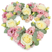 A dense, heart-shaped floral wreath is shown against a bright white backdrop, every inch filled with soft pastel blooms and cool foliage that together create a tender funeral tribute. At its core are sumptuous cream and buttery yellow roses, their petals intricately layered and slightly cupped, spaced evenly to give the heart a clear, graceful outline. Nestled around these roses are clusters of pale pink carnations, their finely frilled petals overlapping to form a velvety, cushion-like texture that softens the entire design. Interspersed through the arrangement are touches of richer mauve and magenta-pink lisianthus, their open, gently fluted flowers drawing the eye deeper into the heart and adding a subtle sense of movement. Tiny yellow-green buds appear here and there, suggesting freshly cut stems and a tribute prepared with care that very day. Silvery-green eucalyptus leaves curve gently through the flowers, their rounded shapes and muted tones framing the heart and adding a cool, calming balance to the warm pastels. The wreath radiates quiet affection, sympathy, and remembrance, ideal for a farewell service in the Queensbury area or for delivery to a family home along Westmoreland Road or near Queensbury Station. The heart shape speaks of love that continues beyond loss, while the soft pinks, creams, and greens evoke peace and comfort. This is the kind of floral tribute someone in Queensbury might choose when they wish to honour a life with beauty, dignity, and a heartfelt final gesture.