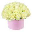 A sophisticated hat box arrangement showcases a lavish dome of creamy white and pale ivory roses, piled so generously that the blooms seem to overflow the top of the container in a soft, rounded mound. Each rose is expertly opened, petals unfurling in layered spirals that reveal gentle hints of pastel yellow at their hearts, giving the entire display a warm, candlelit glow. The roses are packed closely together, creating a plush, seamless surface of velvety petals that evokes both abundance and meticulous craftsmanship. Only the slightest touch of delicate green foliage shows at the base of the blossoms, just enough to suggest their natural origin without disturbing the elegant, monochromatic palette. The flowers rise from a round, pastel pink hat box with a smooth, matte finish, its simple cylindrical shape and blush tone adding a contemporary, fashion-forward feel to this classic rose composition. Set before a stark white background, the soft colours stand out clearly, and every curve of petal and fold of the box is gently defined by even studio lighting. The overall impression is one of quiet luxury and heartfelt celebration, suitable for an anniversary surprise delivered to a home near Queensbury Station or for a romantic gesture shared in a café just off Queensbury's main high street. Although no people are visible, the arrangement suggests the careful touch of a skilled local florist, someone who understands how to balance texture, colour, and shape to create a hat box of roses that feels modern, intimate, and unforgettable.