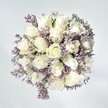 There's a tranquil beauty in this Queensbury-inspired bouquet, as if it gathers the gentle stillness that settles over the local parks at dawn. At the heart are crisp, plush white roses, each petal opening in a flawless spiral, signifying new beginnings and whispered hopes. Threaded between are fragile spurts of statice, tinged with pale lavender that creates a lace-like texture against the creamy roses. The bouquet's purity is heightened by the soft, white-washed backdrop, much like the fresh facades of neighbourhood homes bathed in the first light of day. Subtle greenery peeks through, grounding the arrangement and connecting it to the earthy tranquility of Queensbury's open spaces. Sunlight, diffuse and caressing, enhances every satiny fold of the petals, rendering the whole bouquet luminous, almost weightless. Crafted to offer solace, grace, and quiet celebration, this design lingers in memory like the faintest scent of flowers drifting on a soft local breeze-a poetic gesture for congratulations, comfort, or simply for elevating a cherished home in Queensbury.