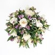 A softly lit, overhead view of a hand-tied bouquet shows creamy white roses, dusky purple alstroemeria buds, and clouds of white gypsophila resting against a pure white background, as if floating in space. The arrangement is rounded and full, with the roses forming the gentle heart of the design; some blooms are fully open, revealing spiralling ivory petals with a hint of champagne at their centres, while others remain slightly closed, holding a quiet sense of promise. Around them, the alstroemeria buds in shades of lavender, plum, and magenta flare into green at their bases, their elongated forms adding movement and a contemporary edge. Fine sprays of baby's breath weave between the larger flowers, their tiny white blossoms creating a misty halo that softens every transition. Deep emerald foliage fans out underneath, glossy leaves peeking between petals to frame the flowers and give the bouquet depth and structure. The light is gentle and even, with no harsh shadows, so every delicate vein in the leaves and every curl of petal is clearly defined yet calm. The overall impression is one of quiet elegance and serenity, like a thoughtful gift brought to a loved one in Queensbury after a walk through the local parks. It feels perfectly suited to moments of comfort, intimate celebrations, or simple thinking of you occasions, radiating a fresh, hopeful beauty that would be just as at home on a bedside table near Queensbury Station as on a dining table prepared for a family gathering.