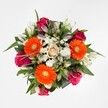 The bouquet in this image, delivered by Flower Delivery Queensbury, bursts with a joyful medley of colours that reflect the vibrancy found in local markets near Queensbury Station. The top-down view reveals a harmonious arrangement where three bold orange Gerberas draw the eye, their yellow-green centres beaming optimism. Nestled amongst them, magenta and fuchsia roses unfold in a mix of plush, velvety blooms and tight, anticipation-filled buds, each one a testament to careful selection and expert pairing. At the heart, a single peach-cream rose exudes gentle sophistication, anchoring the lively palette in softness. Crisp white alstroemeria, both open and budding, meander throughout, adding airy elegance and a whispered promise of more blooms to come. Fluffy clusters of white spray chrysanthemums peek between the larger flowers, contributing a cloud-like lightness that softens the overall look, while generous deep green foliage frames the entire bouquet, adding natural richness and a sense of connectedness to the outdoors. The composition is bathed in clear, even light, allowing every tone and texture to stand out in perfect harmony. This arrangement is ideally suited for celebrating achievements, birthdays, or welcoming new beginnings in Queensbury-its lively colours and tactile luxury capturing both modern flair and traditional charm unique to the area.