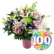 Against a bright, uncluttered white background, a radiant 100th-celebration bouquet fills the left side of the scene, brimming from a cylindrical matte pink vase with a fine ribbed texture that catches the light in soft vertical lines. The arrangement has a rounded, abundant shape, suggesting a careful, professional hand in a local Queensbury flower shop. Dominating the upper section are pale pink Oriental lilies, some fully unfurled into star-shaped blooms that show off their long stamens, others still in smooth, tapered buds that hint at tomorrow's beauty. Around them, layers of blush and dusty rose-coloured roses open gently, their petals curving back in soft spirals that feel romantic and nostalgic, like treasured family stories passed down through generations. Deep purple lisianthus flowers stand out amongst the pastels, their velvety petals adding a note of richness, while clusters of tiny lavender asters, each with a small yellow centre, bring a delicate, almost whimsical charm. Bright lime green button chrysanthemums dot the bouquet with fresh, upbeat colour, and fine sprays of white baby's breath drift between the larger blooms, lending a cloud-like softness. A mix of dark green foliage frames the flowers, some leaves broad and glossy, others slender and feathery, creating both contrast and fullness. Just overlapping the lower right edge of the bouquet is a round, glossy foil balloon, its entire surface sprinkled with multicoloured confetti dots in cheerful shades of red, orange, yellow, green, blue, and purple. In the middle, large white numbers 100 appear slightly raised, clearly marking a centenary milestone. The composition feels joyful and proud, ideal for honouring a 100th birthday or anniversary in Queensbury with style and affection.