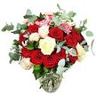 A lush, romantic bouquet bursts from a clear glass vase, photographed cleanly against a white background so that every flower and leaf becomes the star. The design is dominated by an abundance of deep red and bright scarlet roses, their velvety petals layered and full, some in tight, promising buds and others open wide in luxurious, cup-shaped blooms that speak of love and devotion. Threaded gently between the reds are creamy white and ivory roses, along with a few white flowers tinted softly with pale pink, creating a luminous contrast that brings balance and calm to the passionate colour palette. Tiny clusters of bright pink filler flowers nestle among the larger roses, introducing a light, playful note and fine texture that makes the bouquet feel even more intricate. Surrounding the roses, generous sprays of blue-green eucalyptus with rounded, slightly silvery leaves fan outward, lending a cool, contemporary edge reminiscent of the fresh greenery you might notice in Queensbury's quiet residential gardens on a crisp morning. Deeper green rose foliage peeks through at different levels, filling out the composition and reinforcing its full, rounded shape. The glass vase has a gently curved base that narrows toward the neck, clearly revealing the bundled stems and the clean water supporting them, which adds to the impression of freshly arranged flowers. The overall effect is one of classic elegance, ideal for romantic occasions, anniversaries, or heartfelt thank-you gifts delivered across Queensbury, creating an atmosphere of warmth, intimacy, and refined beauty in any room.