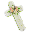 A traditional white floral cross for a funeral or memorial is displayed here in careful detail, set against a pure white background that makes its form and shadow stand out with calm clarity. The body of the cross is entirely covered in small white chrysanthemums, especially button-style blooms, tightly clustered so that not a glimpse of the underlying frame is visible. This dense, cloud-like covering gives the design a soft, comforting presence, as though the flowers themselves are gently embracing the memory of the person being honoured. Around the outer edge, a slim lime green ribbon is meticulously wrapped, providing a fresh outline that lightly frames the white and suggests new life and hope amid sorrow. At the centre crossing point of the vertical and horizontal arms, the florist has created a tender focal spray. Several open roses in sympathetic pastel tones-pale pink, peachy apricot, and creamy ivory-are grouped together, their rounded, layered petals adding warmth and a sense of personal love. Fine sprigs of lavender-coloured filler flowers and arching green fern fronds weave through the roses, offering contrast in both colour and texture while remaining restrained and tasteful. The balanced lighting and simple background ensure that every petal and frond can be clearly seen and appreciated. This kind of cross would be chosen by families in Queensbury for a church service, crematorium farewell, or graveside tribute, a quietly powerful arrangement that conveys faith, comfort, and a heartfelt final goodbye from those who remain behind.
