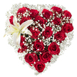 Against a crisp, studio-white background this heart-shaped bouquet reads like a single, eloquent message of love. Dozens of deep crimson roses-each petal velvety and richly saturated-are packed tightly to form the unmistakable silhouette of a heart; some blooms sit as tight, glossy buds while others unfurl into broad, shadowed cups that catch the light and reveal layered textures. Between those lush red forms drift clouds of tiny white baby's breath (Gypsophila), their star-like florets softening the composition with an airy, almost whispered contrast that brightens the heart's edges and fills the gaps with delicate texture. Nestled in the upper-left curve, a single large white lily opens like a quiet punctuation mark: its broad, pristine petals radiate a cool, creamy white, the throat gently warmed by a pale yellow, and its prominent yellow stamens offer a slender note of warmth against the crimson. The arrangement is photographed with gentle, even lighting that emphasizes petal grain, shadow depth, and the subtle sheen on rose surfaces, making the bouquet feel tactile and near enough to smell-warm, faintly sweet rose perfume threaded with the green, powdery scent of gypsophila and the faint spice of lily pollen. Sensed more than merely seen, the piece carries a formal yet intimate mood-suitable for anniversaries, declarations of devotion, or as a carefully crafted tribute. A Queensbury florist would lay out these exact elements for a client seeking a traditional, luxurious expression of affection, mindful of proportion, balance, and the quiet drama created by a single white lily against a sea of passionate red.